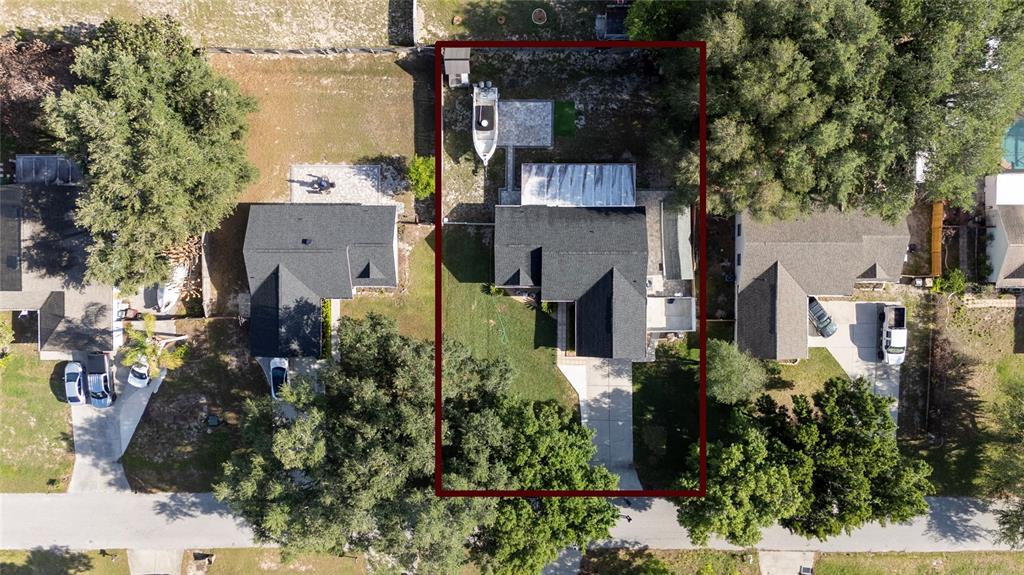An aerial view shows a single-family home with a driveway, backyard, and boat storage — 10618 REAGANS RUN DRIVE, CLERMONT, FL