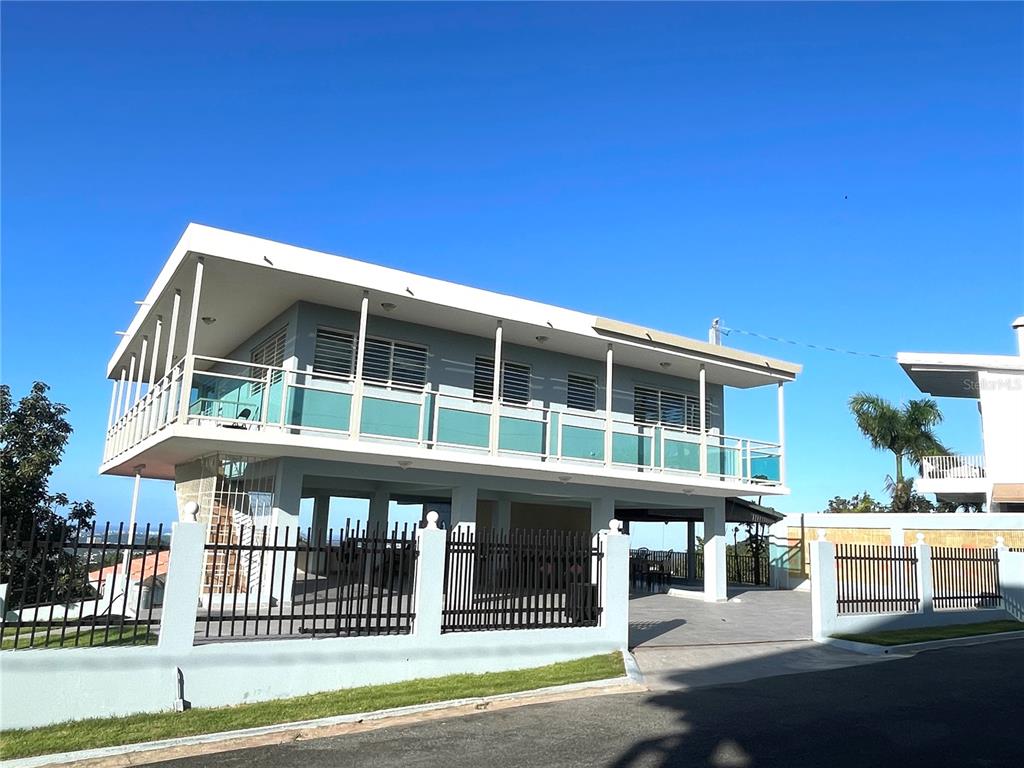 A two-story house with a balcony and a fenced-in ground level parking area — LOT 5-A HOLLYWOOD UNIT 5-A, SAN JUAN, PR