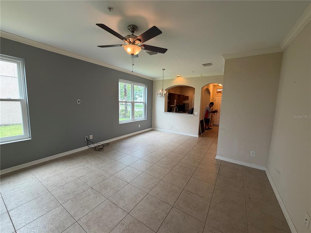 A living room with tile floors, a ceiling fan, and an arched kitchen pass-through — 1146 GRANTHAM DRIVE, SARASOTA, FL