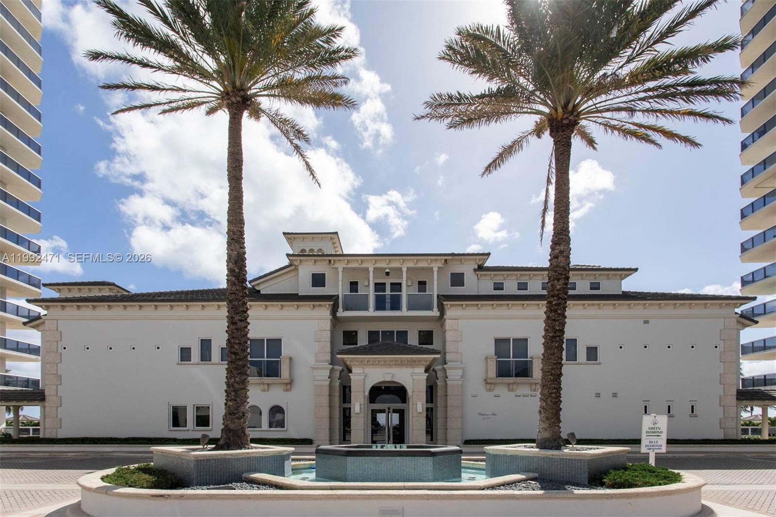 A low-rise building stands between two tall towers with palm trees and a central fountain — 4779 Collins Ave # 808, Miami Beach FL 33140, MIAMI BEACH, FL