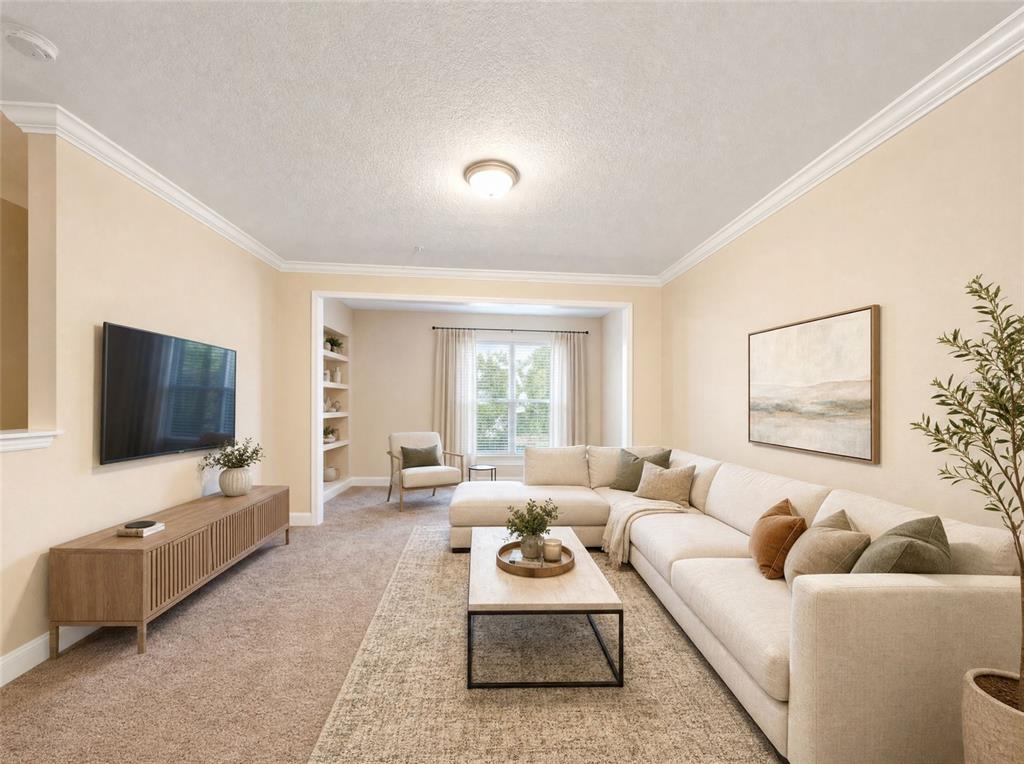A living room features a sectional sofa, a television, a coffee table, and built-in shelving — 143 SOUTHERN PECAN CIRCLE UNIT 201, WINTER GARDEN, FL