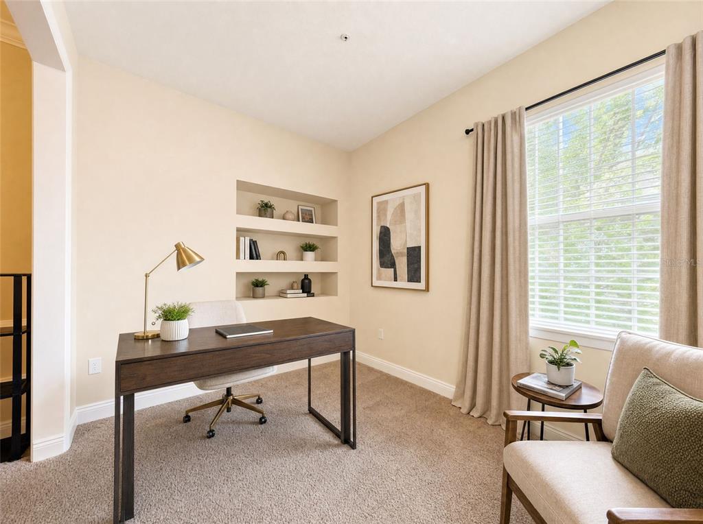 A home office features a wooden desk, a chair, built-in wall niches, and a window — 143 SOUTHERN PECAN CIRCLE UNIT 201, WINTER GARDEN, FL