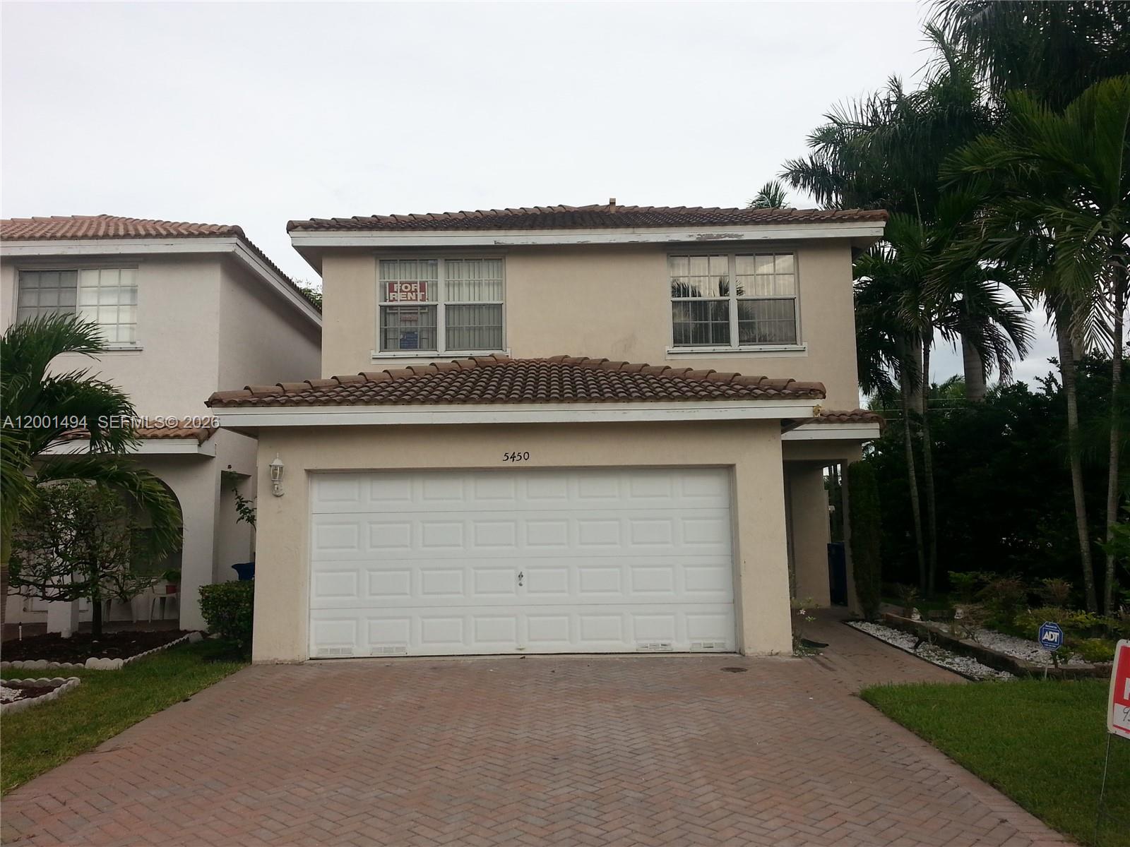 A two-story beige house with a tiled roof and a white two-car garage — 5450 NW 94th Ter, Sunrise FL 33351, SUNRISE, FL