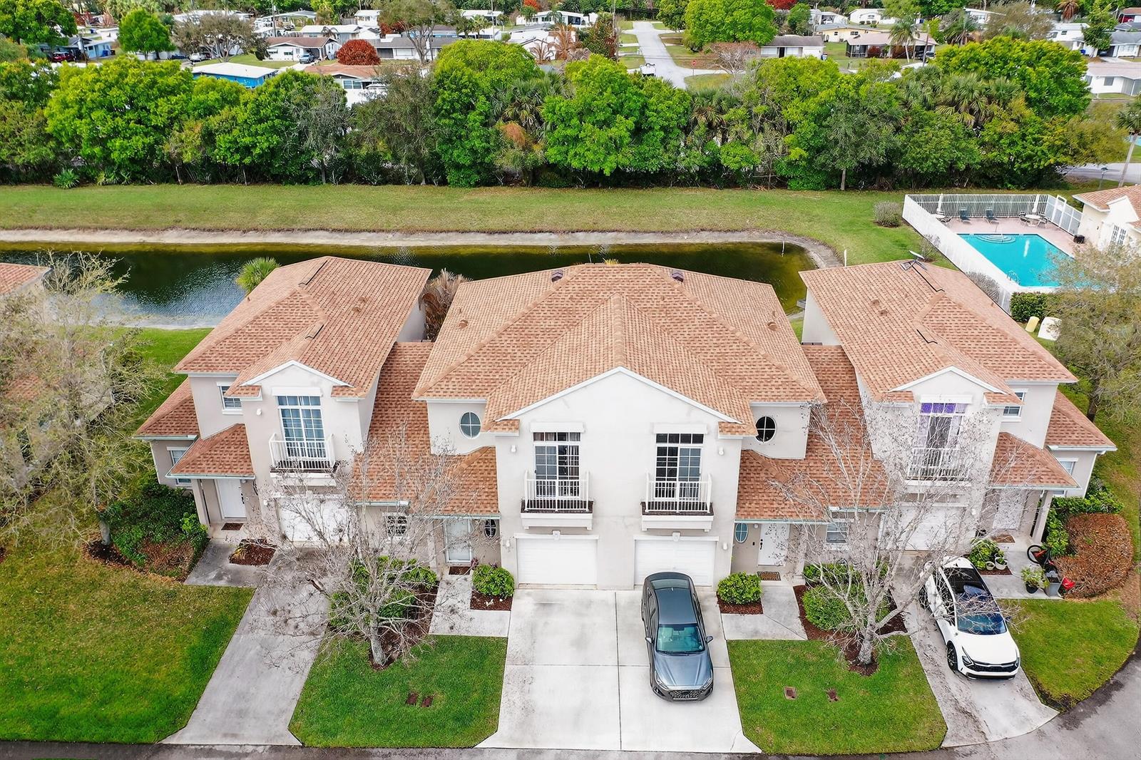 An aerial view shows a multi-unit residential building with tan roofs, balconies, and attached garages — 1911 77th Drive, Vero Beach FL 32966, VERO BEACH, FL