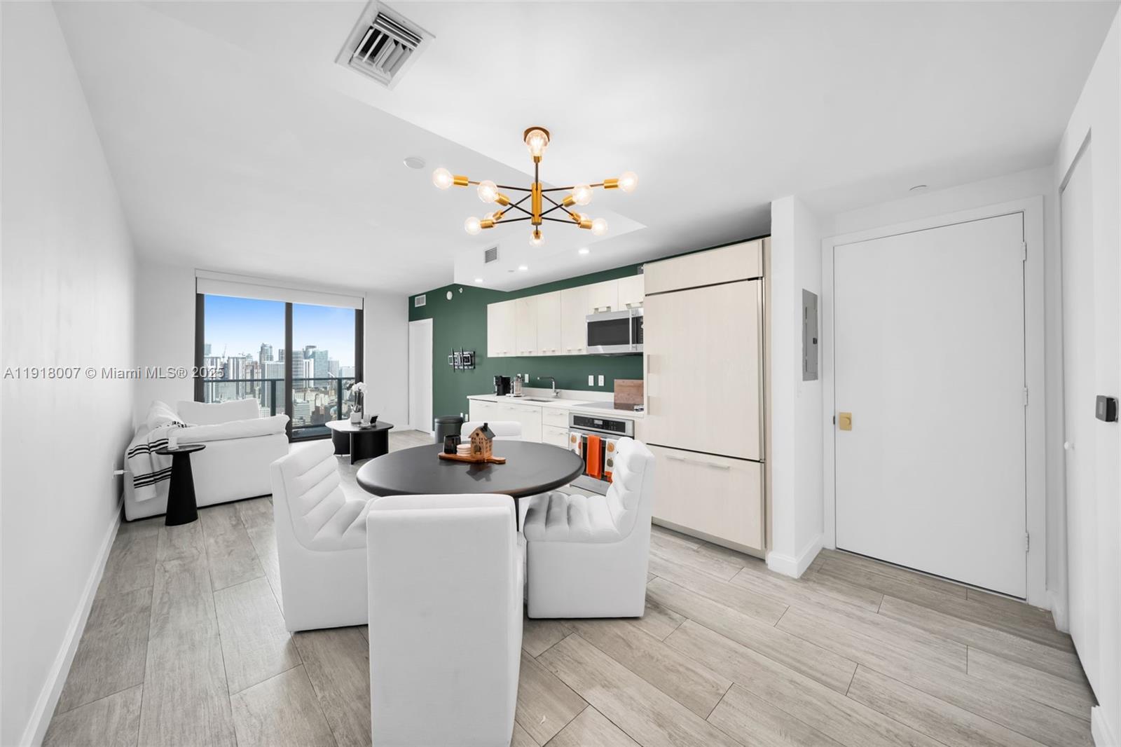 This open-concept living area features a kitchen with green accents, a dining set, and balcony views — 45 SW 9th St # 3909, Miami FL 33130, MIAMI, FL