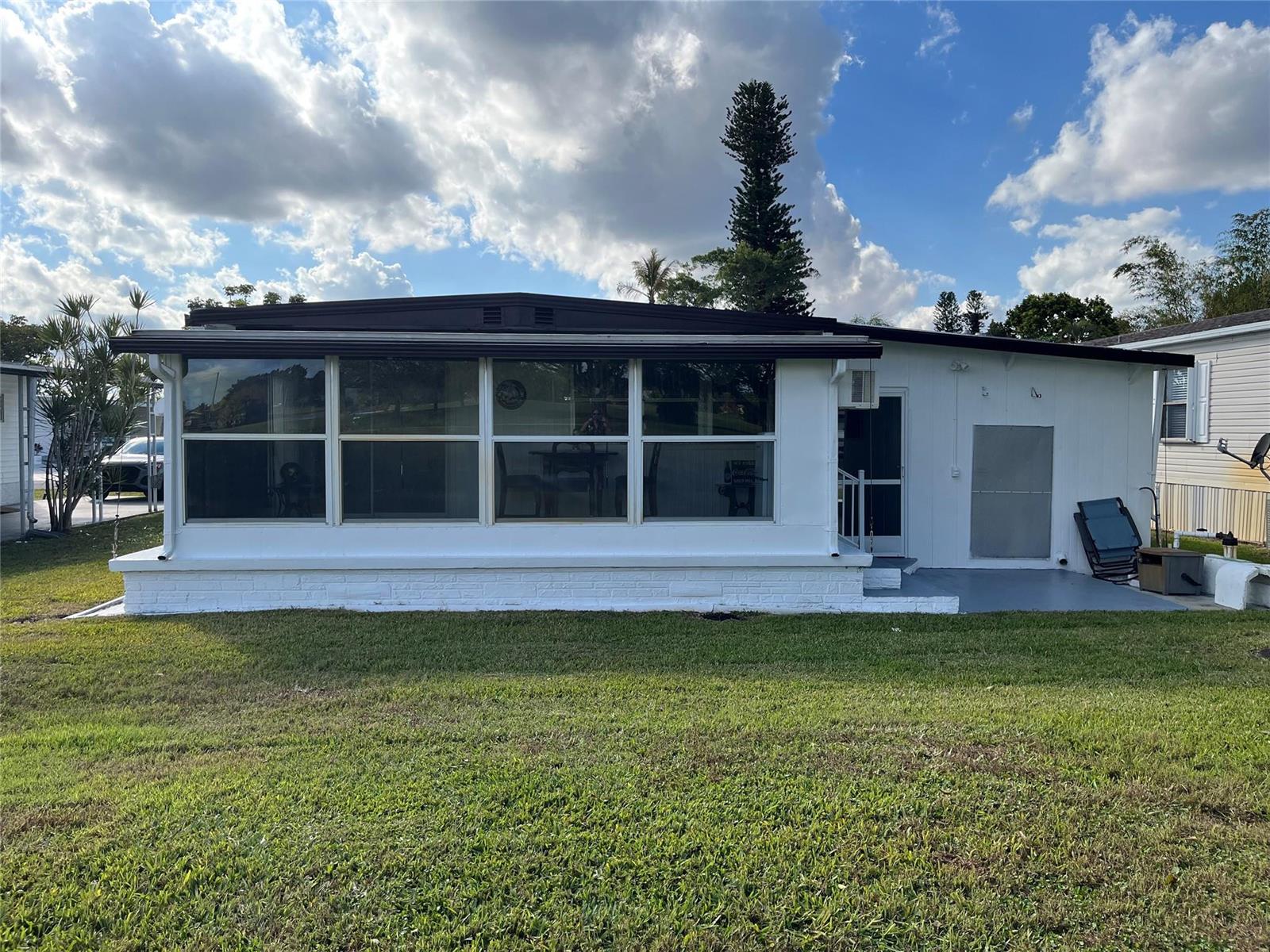 A single-story mobile home with a white brick base, large front windows, and a lawn — 2196 SW 83rd Avenue, Davie FL 33324, DAVIE, FL