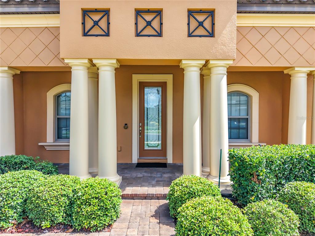 The exterior of a house features a front door flanked by four large white columns — 1569 KATIE COVE, SANFORD, FL