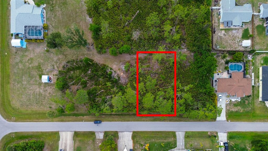 An aerial view shows a rectangular, wooded vacant lot outlined in red along a road — 5263 ELLSWORTH TERRACE, PORT CHARLOTTE, FL