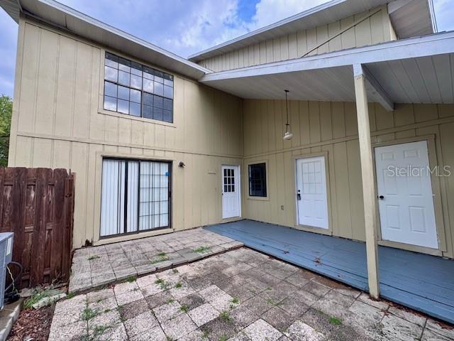 A two-story house exterior features a paved patio, a covered deck, and multiple entry doors — 4546 LIGHTHOUSE CIRCLE UNIT 14, ORLANDO, FL