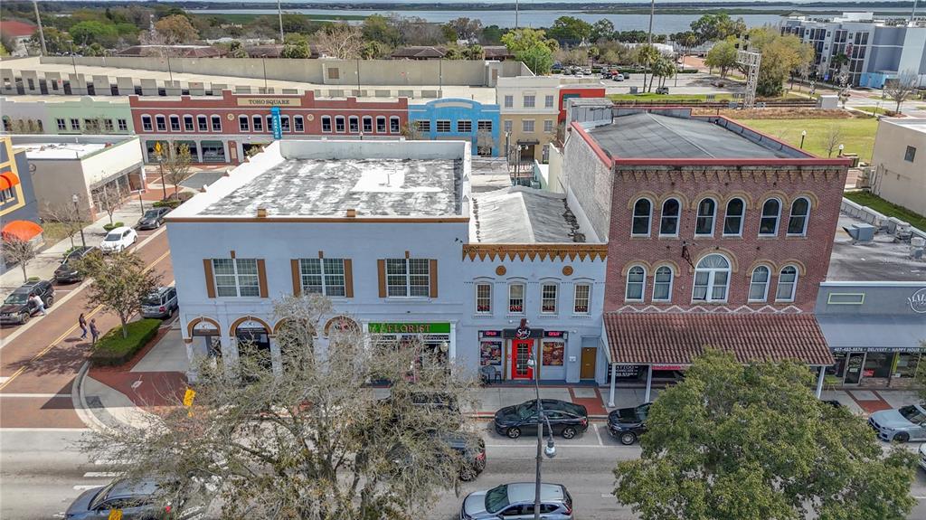 An aerial view shows a row of historic brick and stucco commercial buildings downtown — 24 BROADWAY AVENUE UNIT A, KISSIMMEE, FL