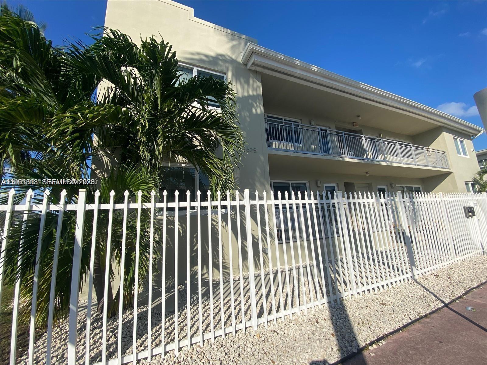 A two-story apartment building features a white metal fence and a palm tree out front — 625 77th St # 2, Miami Beach FL 33141, MIAMI BEACH, FL