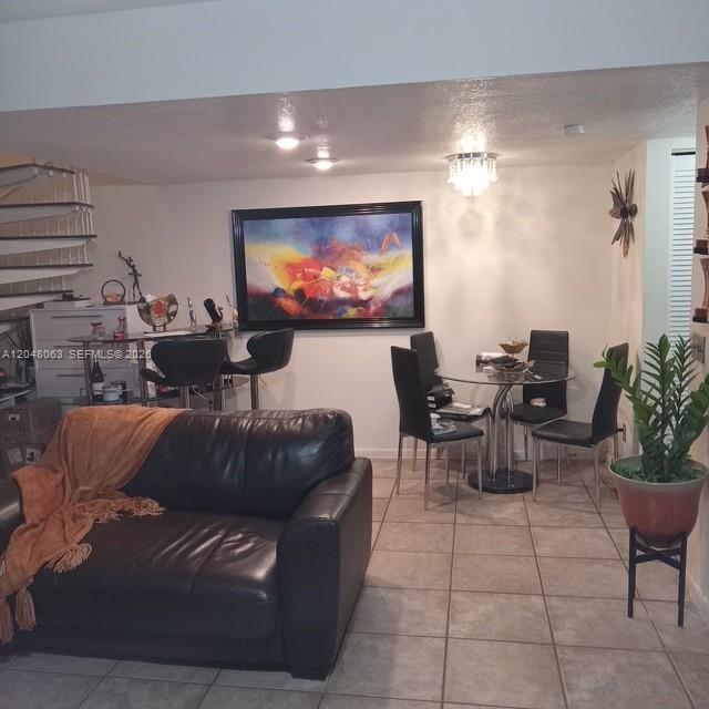 A living and dining area features a black leather sofa, glass table, and spiral staircase — 8301 SW 157th Ave # 206, Miami FL 33193, MIAMI, FL