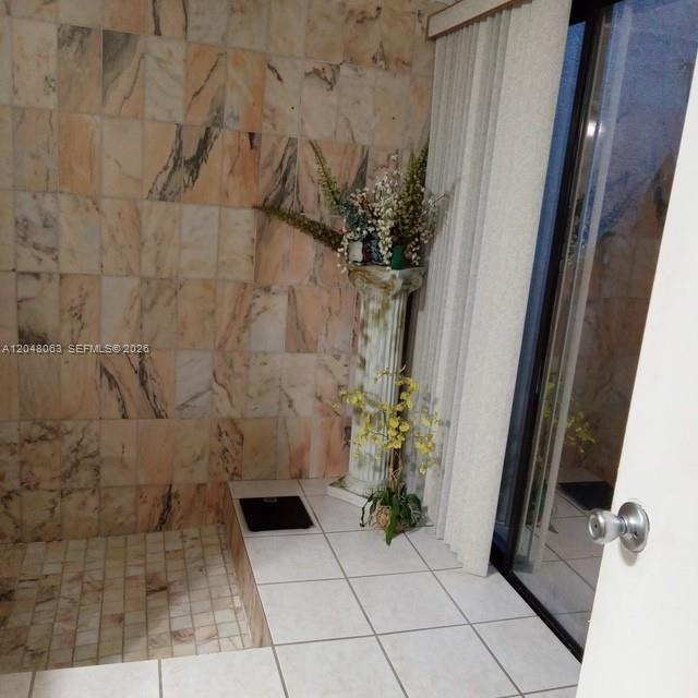 A bathroom features marble wall tiles, a pedestal stand with artificial plants, and sliding doors — 8301 SW 157th Ave # 206, Miami FL 33193, MIAMI, FL