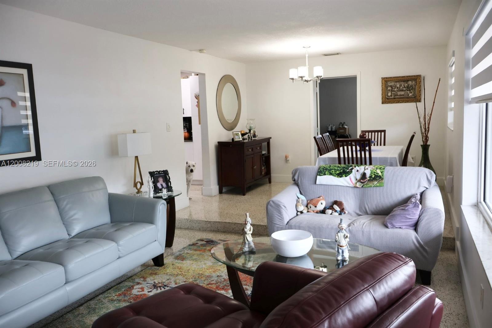A living room features light gray and dark red sofas, a glass coffee table, and terrazzo floors — 11206 SW 1st St, Sweetwater FL 33174, SWEETWATER, FL