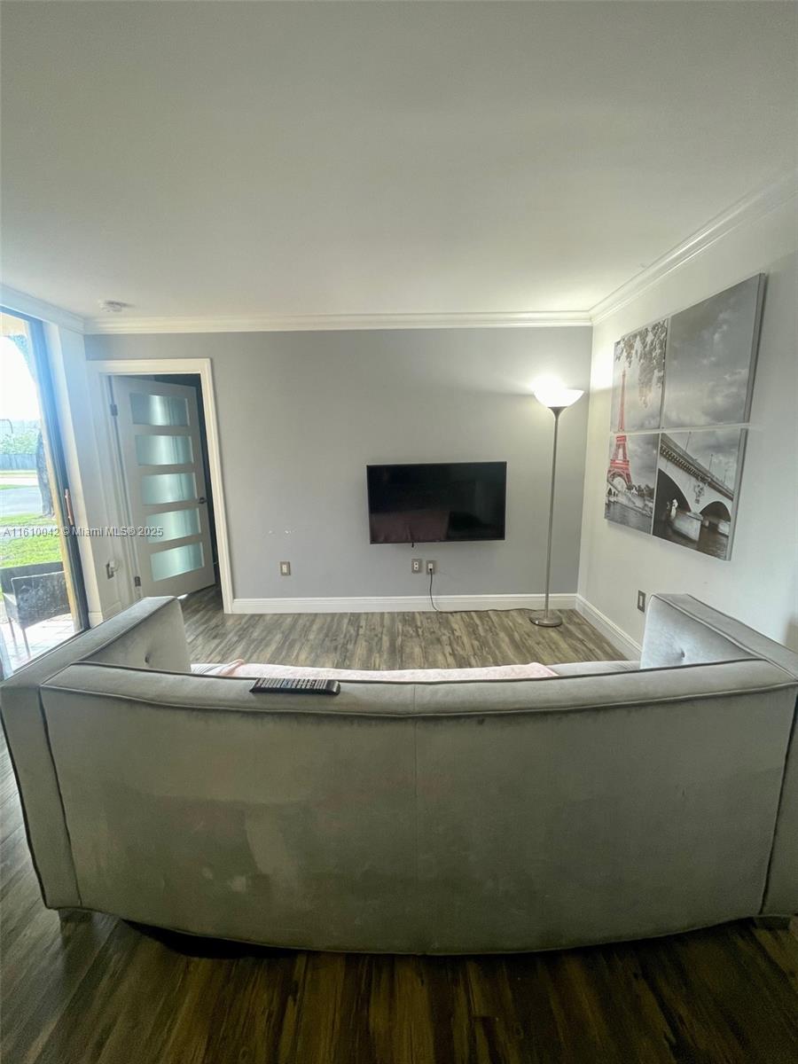 A living room features a wall-mounted television, a grey sofa, and a floor lamp — 11800 SW 18th St # 4, Miami FL 33175, MIAMI, FL