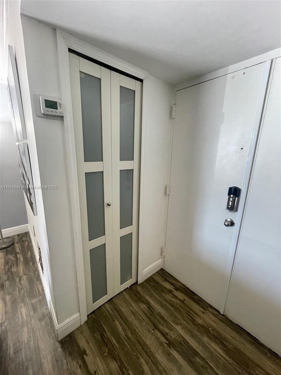 A hallway features wood-look flooring, a white door with a smart lock, and a bi-fold closet — 11800 SW 18th St # 4, Miami FL 33175, MIAMI, FL