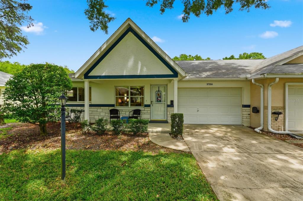 A single-story house with a white garage, a small front porch, and a grassy lawn — 9755 SW 94TH TERRACE UNIT A, OCALA, FL