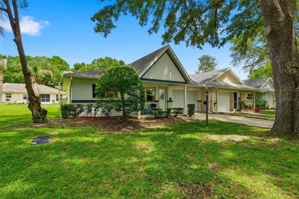 A single-story duplex with a light-colored exterior, attached garages, and a large front lawn — 9755 SW 94TH TERRACE UNIT A, OCALA, FL