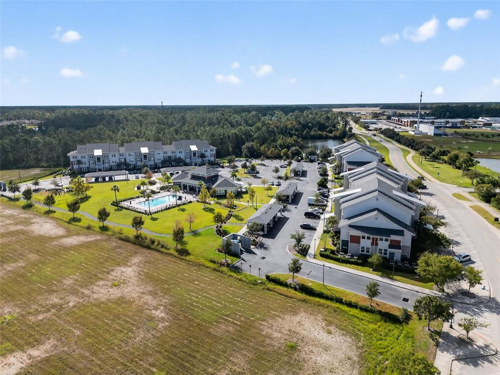 An aerial view shows a multi-building apartment complex with a pool and parking lots — 469 BULLDOG DRIVE UNIT 3, PALM COAST, FL