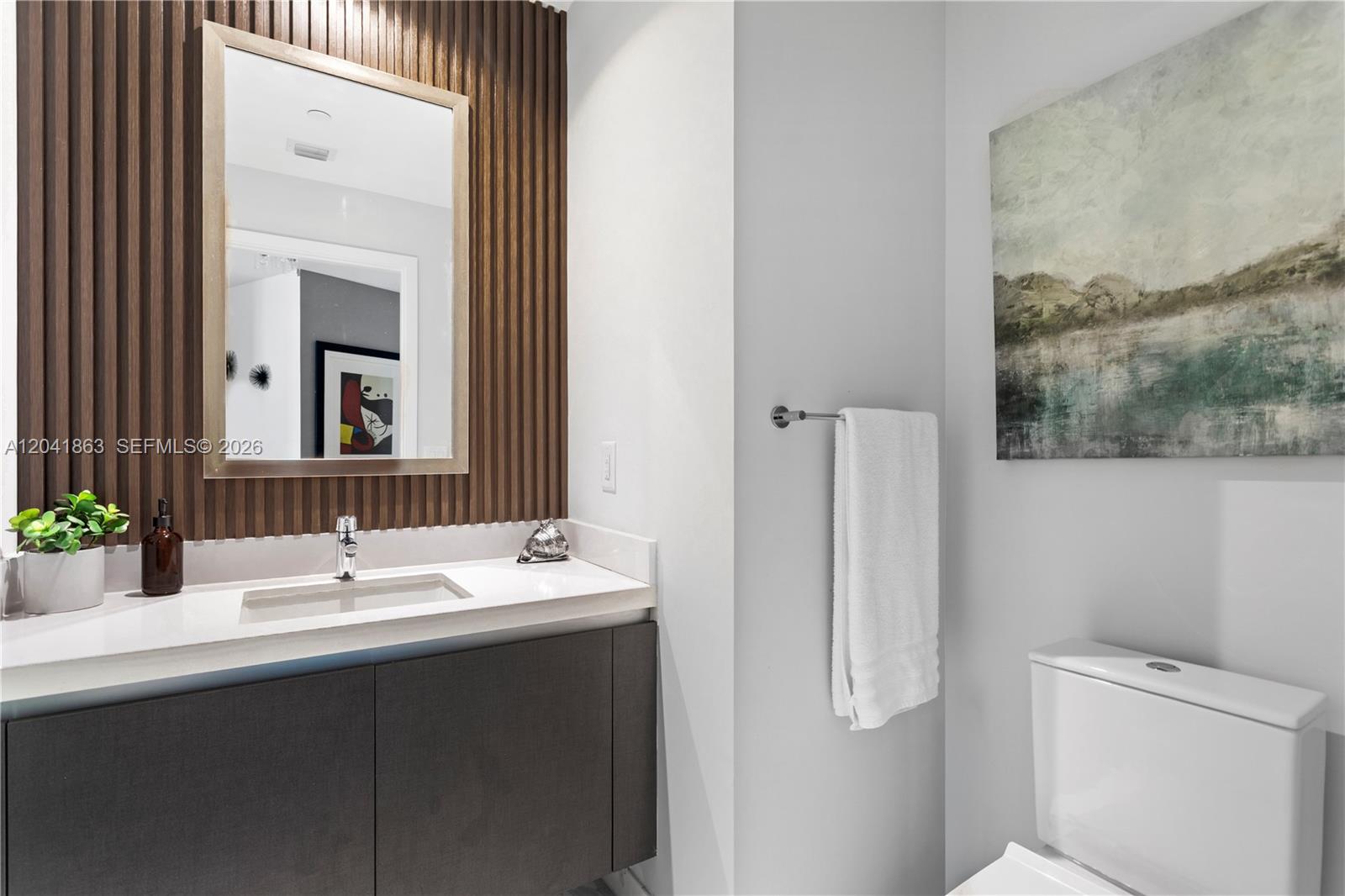 A modern bathroom features a wood-slat accent wall, a floating vanity, and a white toilet — 851 NE 1st Ave # 3900, Miami FL 33132, MIAMI, FL