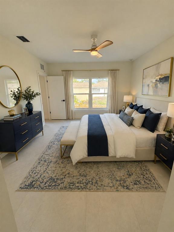 An open-concept dining area and kitchen feature a round glass table, wood-toned cabinetry, and tile flooring — 5813 REGENT ROAD, VENICE, FL