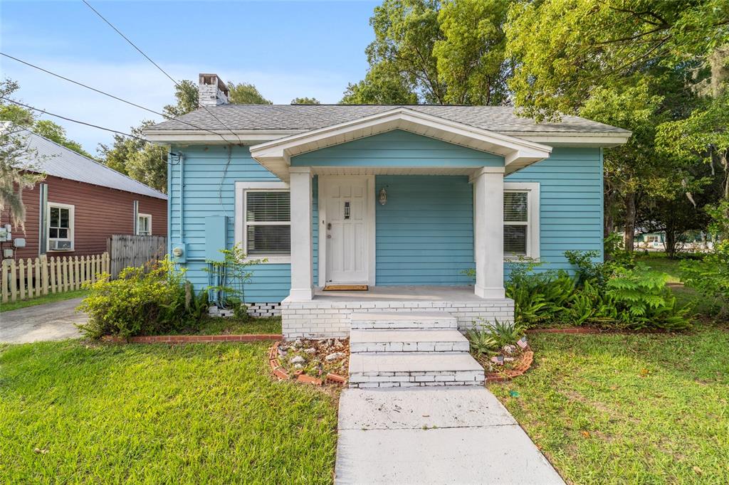 A light blue, single-story house with a front porch and white trim stands on grass — 20837 WALNUT STREET, DUNNELLON, FL