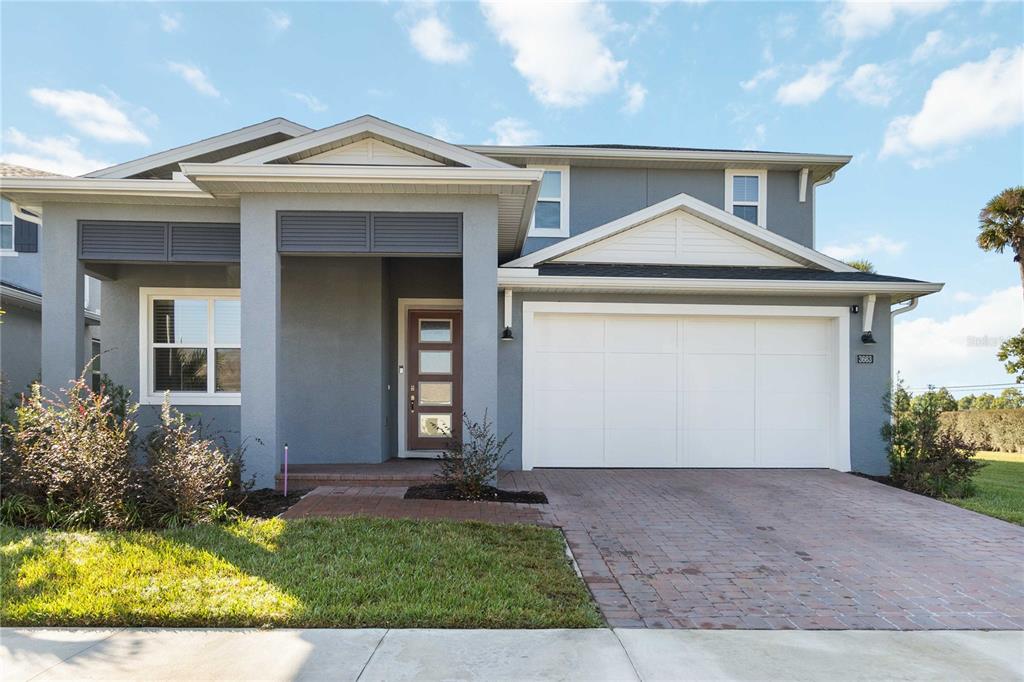 A two-story gray house with a white garage door and a front porch — 3663 ARBORDALE LOOP, SANFORD, FL