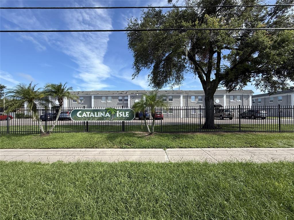 A green sign for Catalina Isle stands before a two-story apartment building behind a fence — 2769 L B MCLEOD ROAD UNIT 2769A, ORLANDO, FL