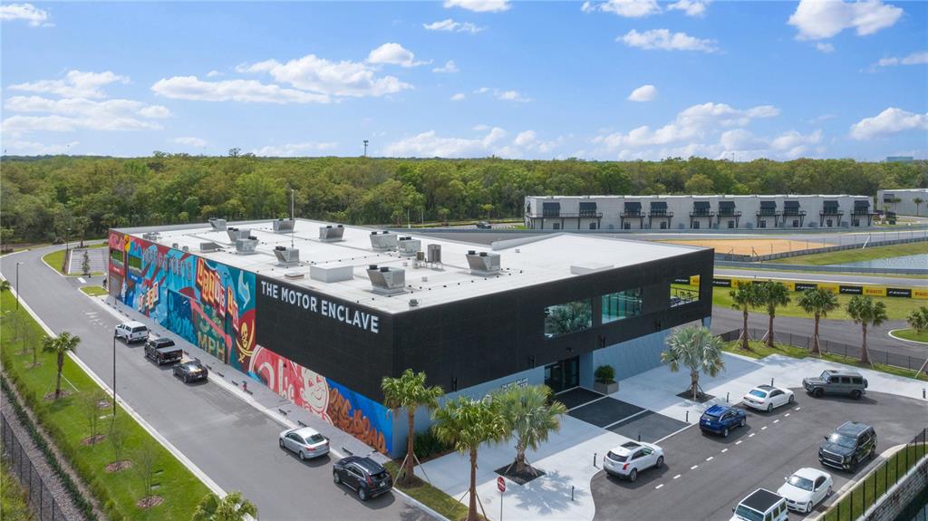 An aerial view of a modern commercial building with a mural and adjacent racetrack — 6500 MOTOR ENCLAVE WAY UNIT 506, TAMPA, FL