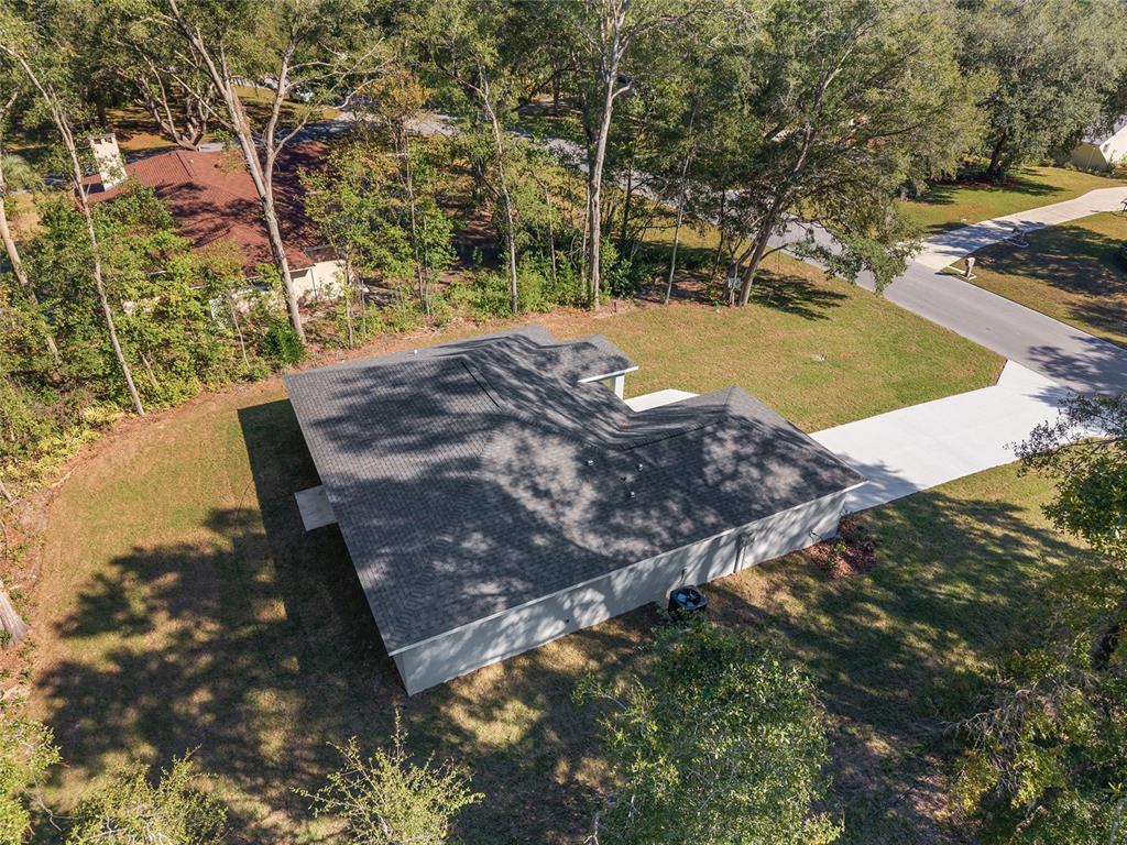 An aerial view shows a single-story house with a gray roof and a concrete driveway — 9776 SW 196TH CIRCLE, DUNNELLON, FL