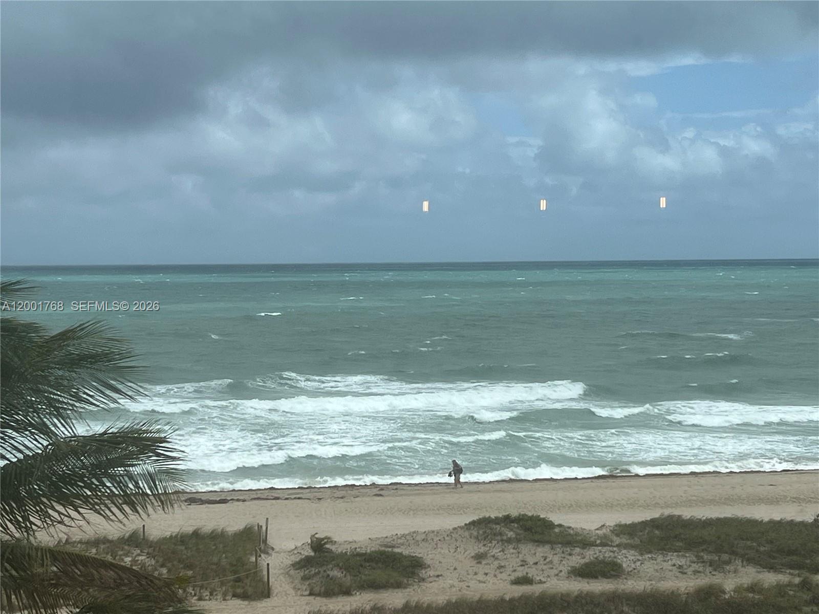 A view of a sandy beach and the ocean under a cloudy sky — 710 N Ocean Blvd # 408, Pompano Beach FL 33062, POMPANO BEACH, FL