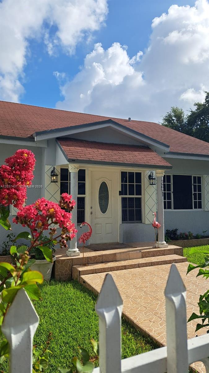 A single-story house features a tiled entryway, a white front door, and two flamingo statues — 351 NW 31st St, Miami FL 33127, MIAMI, FL