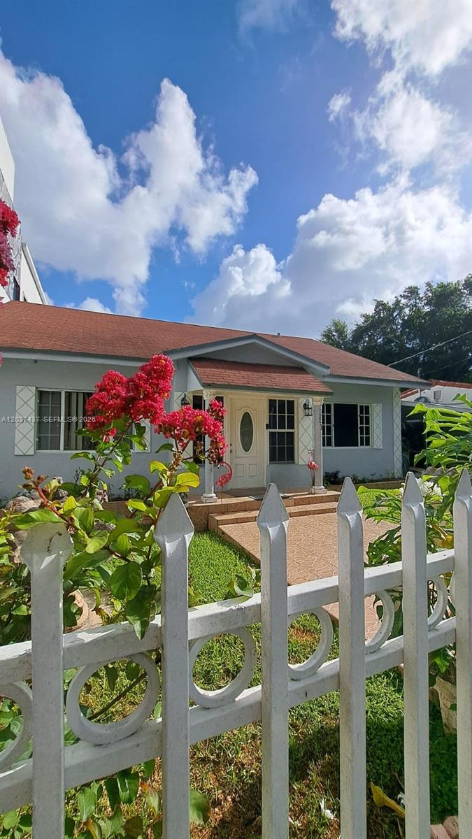 A single-story house with a light blue exterior, red roof, and white picket fence — 351 NW 31st St, Miami FL 33127, MIAMI, FL