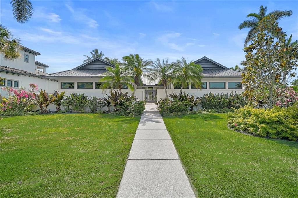 A single-story house with a metal roof and a central walkway through a landscaped lawn — 627 OWL WAY, SARASOTA, FL