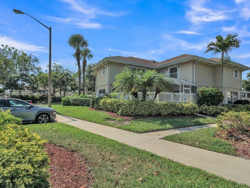A two-story beige house with a screened-in patio and palm trees in the front yard — 6403 Dryden Ct, Boynton Beach FL 33436, BOYNTON BEACH, FL