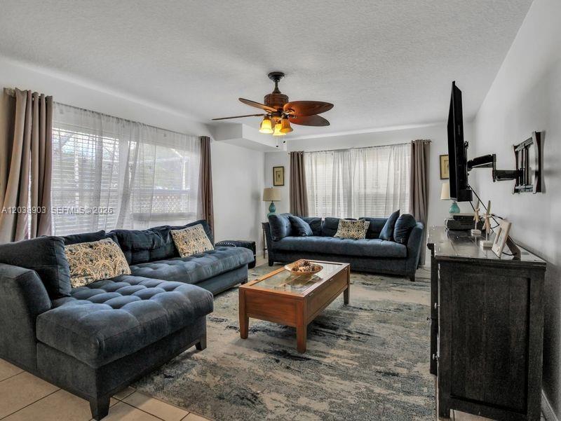 A living room features two dark blue sofas, a wooden coffee table, and a ceiling fan — 6403 Dryden Ct, Boynton Beach FL 33436, BOYNTON BEACH, FL
