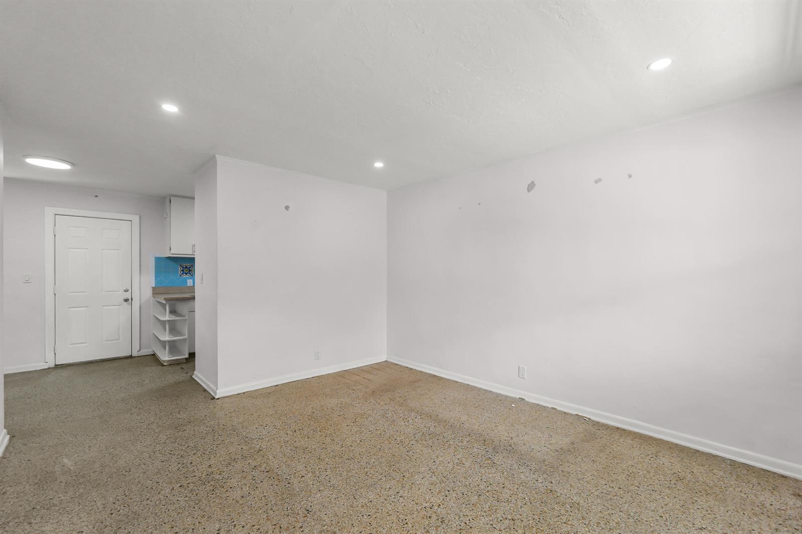 An empty room with beige speckled carpet, white walls, recessed lighting, and a white door — 429 Lytle Street, West Palm Beach FL 33405, WEST PALM BEACH, FL