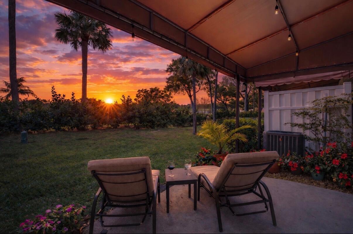 Two lounge chairs sit on a patio overlooking a grassy yard at sunset — 5282 Sapphire Valley, Boca Raton FL 33486, BOCA RATON, FL