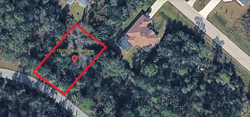 This aerial map shows a vacant, wooded residential lot outlined in red — 15074 CAROUSEL LANE, PORT CHARLOTTE, FL