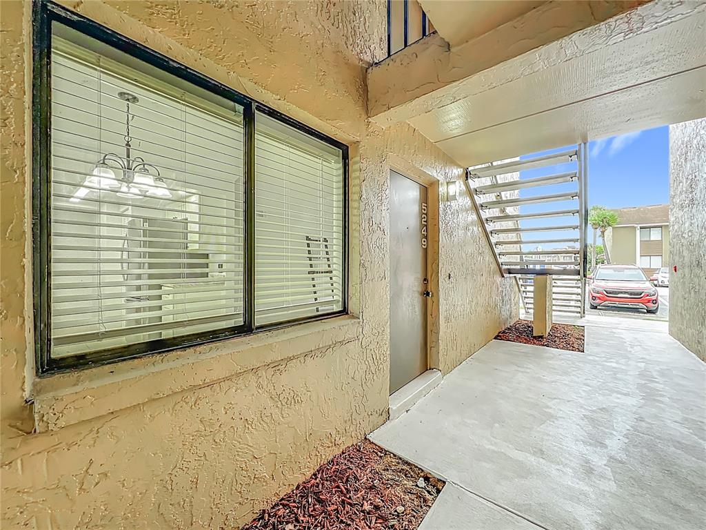 An exterior view shows a building entrance with a window, a door numbered 5249, and stairs — 5249 VINELAND ROAD, ORLANDO, FL
