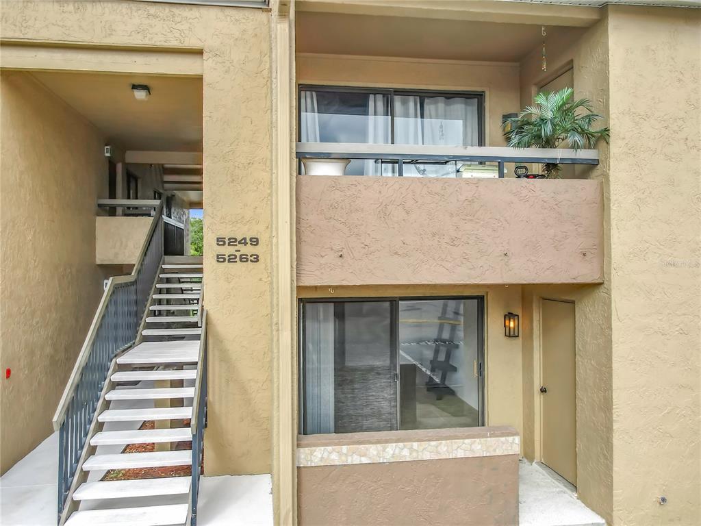 An exterior view of a two-story apartment building with a staircase and balconies — 5249 VINELAND ROAD, ORLANDO, FL