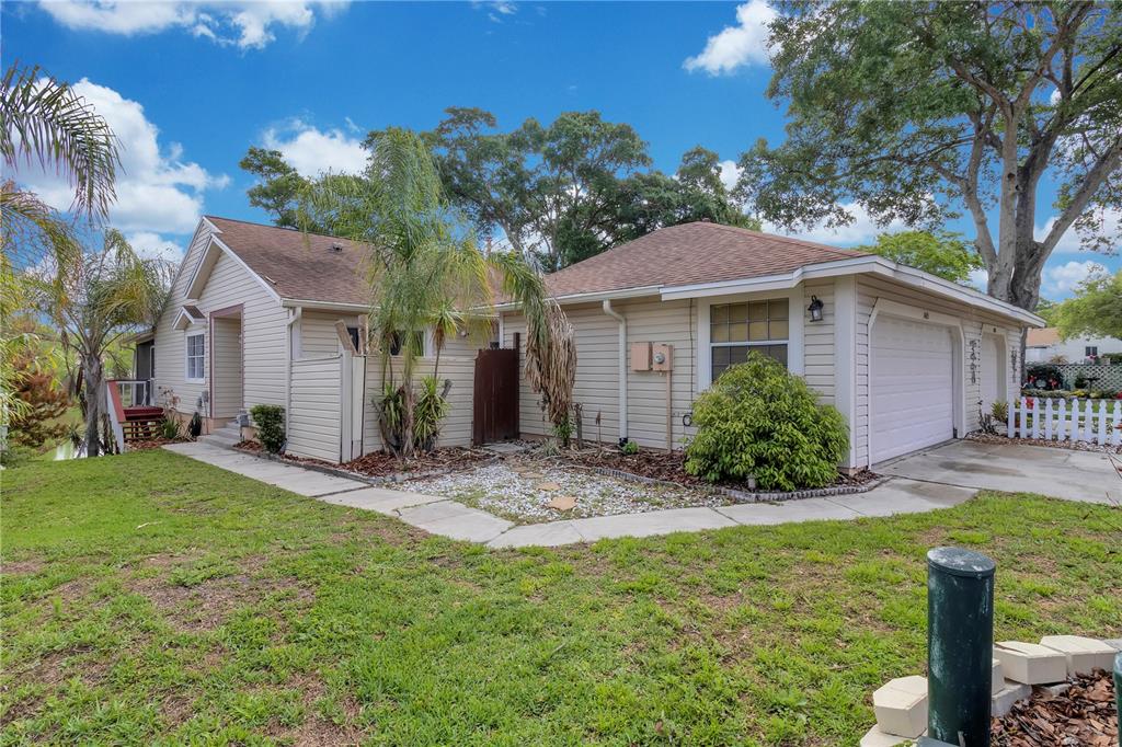 A single-story house with beige siding, a two-car garage, and a front yard — 1405 CRICKET COURT, LONGWOOD, FL
