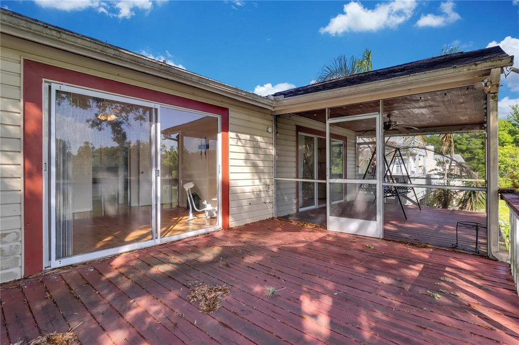 A wooden deck with a screened-in porch area and sliding glass doors leading indoors — 1405 CRICKET COURT, LONGWOOD, FL