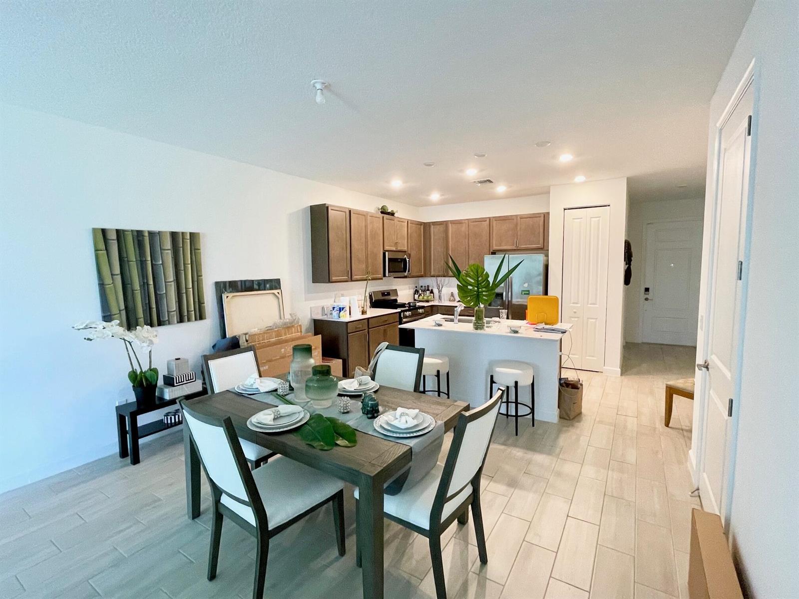 A hallway with light wood-look tile flooring, white walls, and three white doors — 13809 Hero Path, Delray Beach FL 33484, DELRAY BEACH, FL