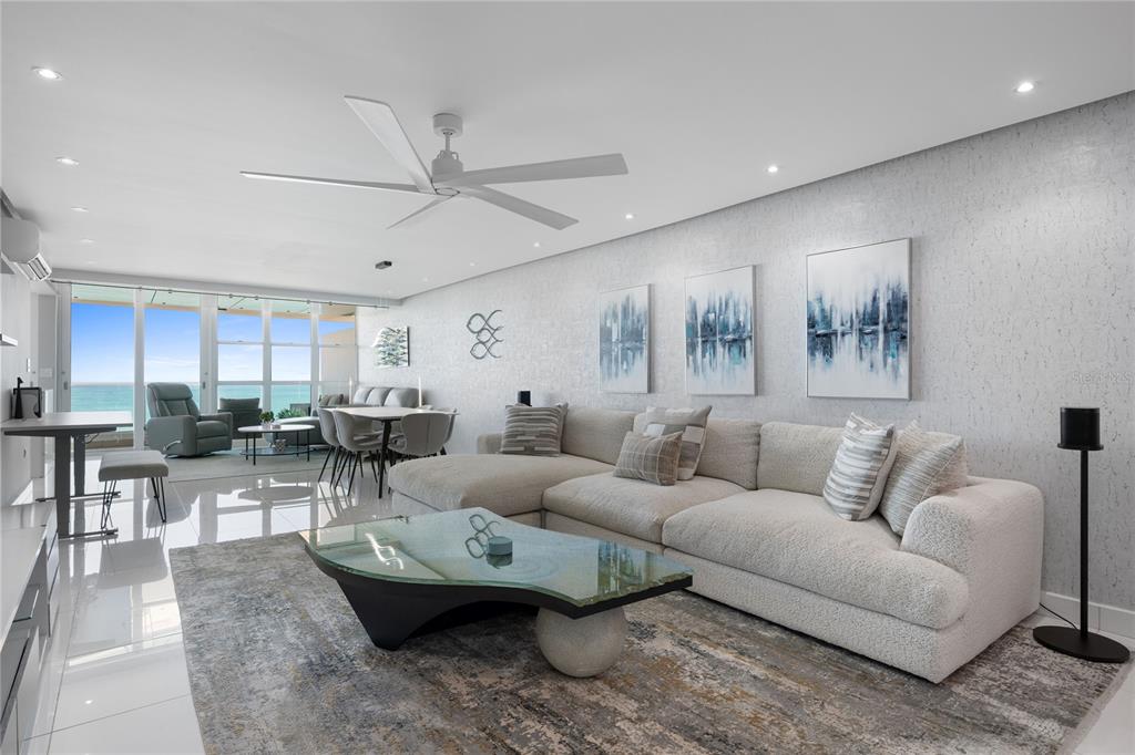 A modern living room features a large sectional sofa, glass coffee table, and ocean views — 5575 AVENIDA ISLA VERDE UNIT 903, CAROLINA, PR