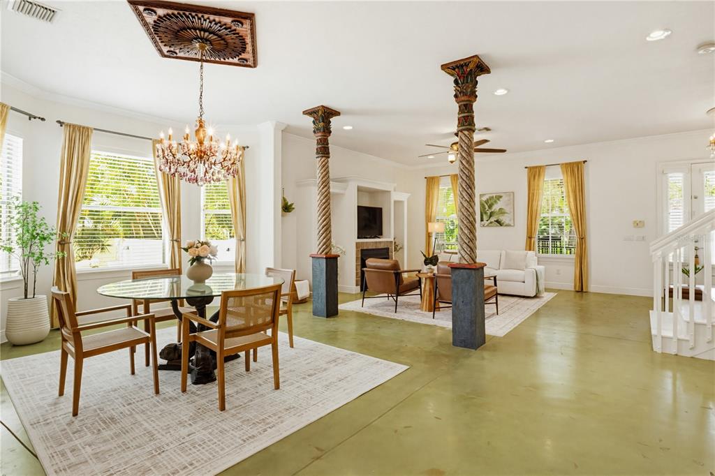 A dining and living area features two decorative columns, a crystal chandelier, and concrete floors — 4104 SARASOTA AVENUE, SARASOTA, FL