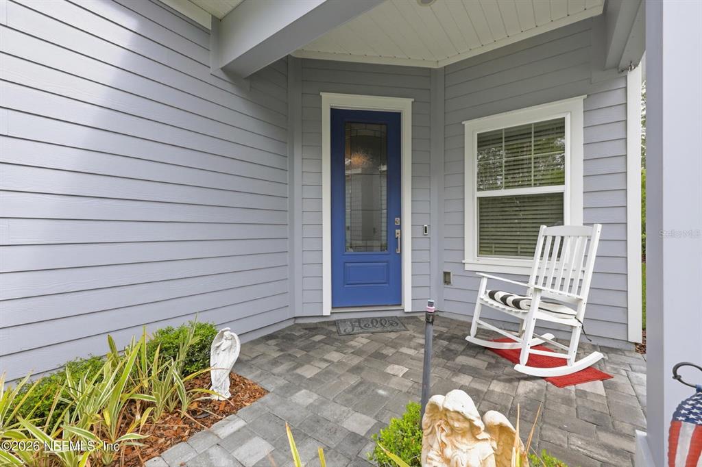 A blue front door with a glass panel sits on a porch with a rocking chair — 312 STILLWATER BOULEVARD, ST JOHNS, FL