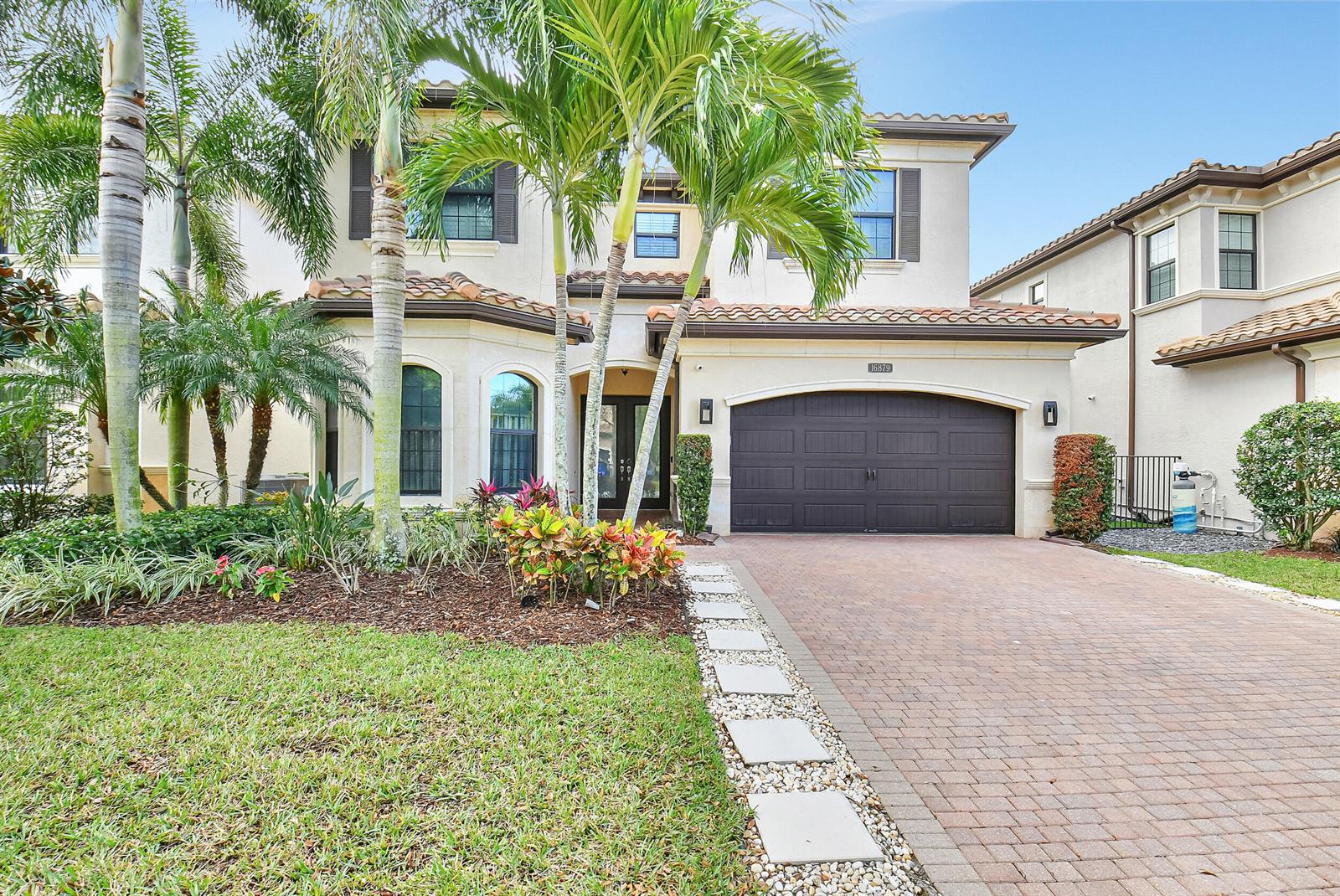 A two-story house with a brown garage door, palm trees, and a paved driveway — 16879 Bridge Crossing Circle, Delray Beach FL 33446, DELRAY BEACH, FL