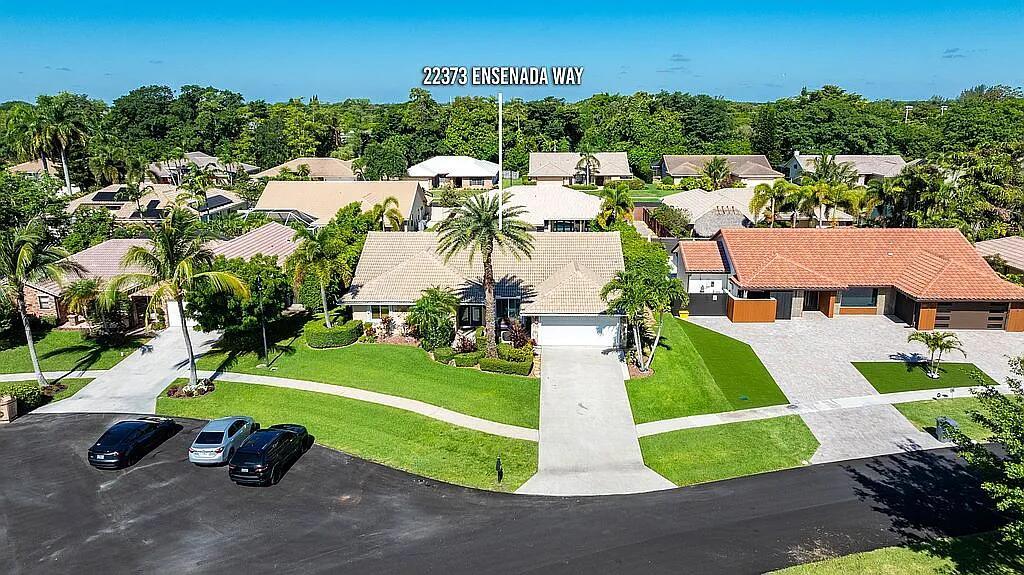 An aerial view shows a suburban house with a tiled roof, driveway, and palm trees — 22373 Ensenada Way, Boca Raton FL 33433, BOCA RATON, FL
