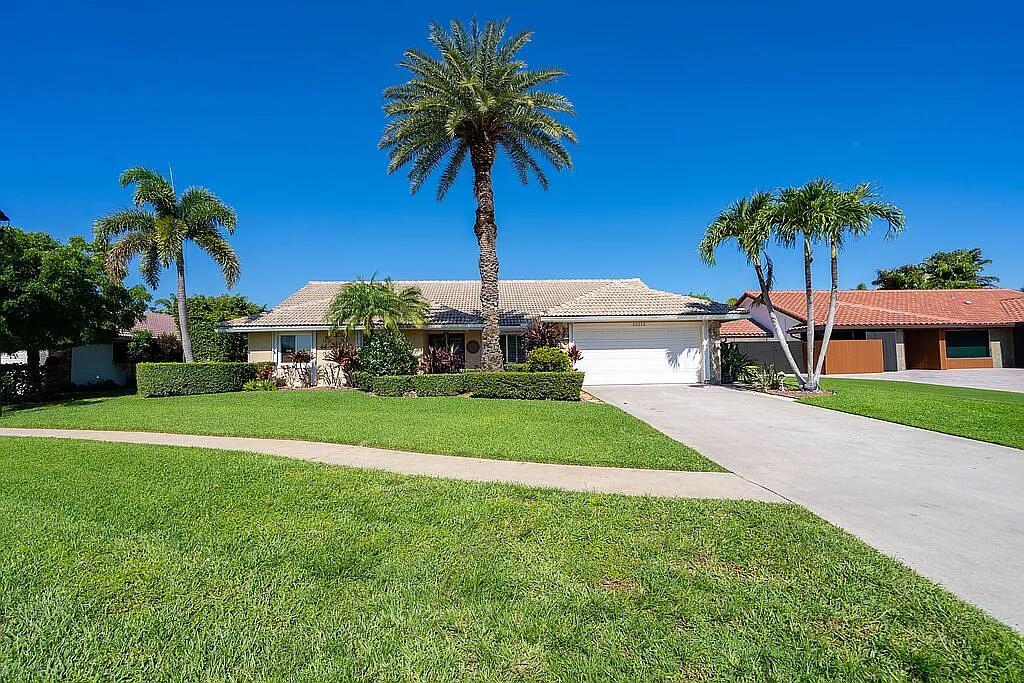 A single-story house with a white garage, palm trees, and a green lawn — 22373 Ensenada Way, Boca Raton FL 33433, BOCA RATON, FL